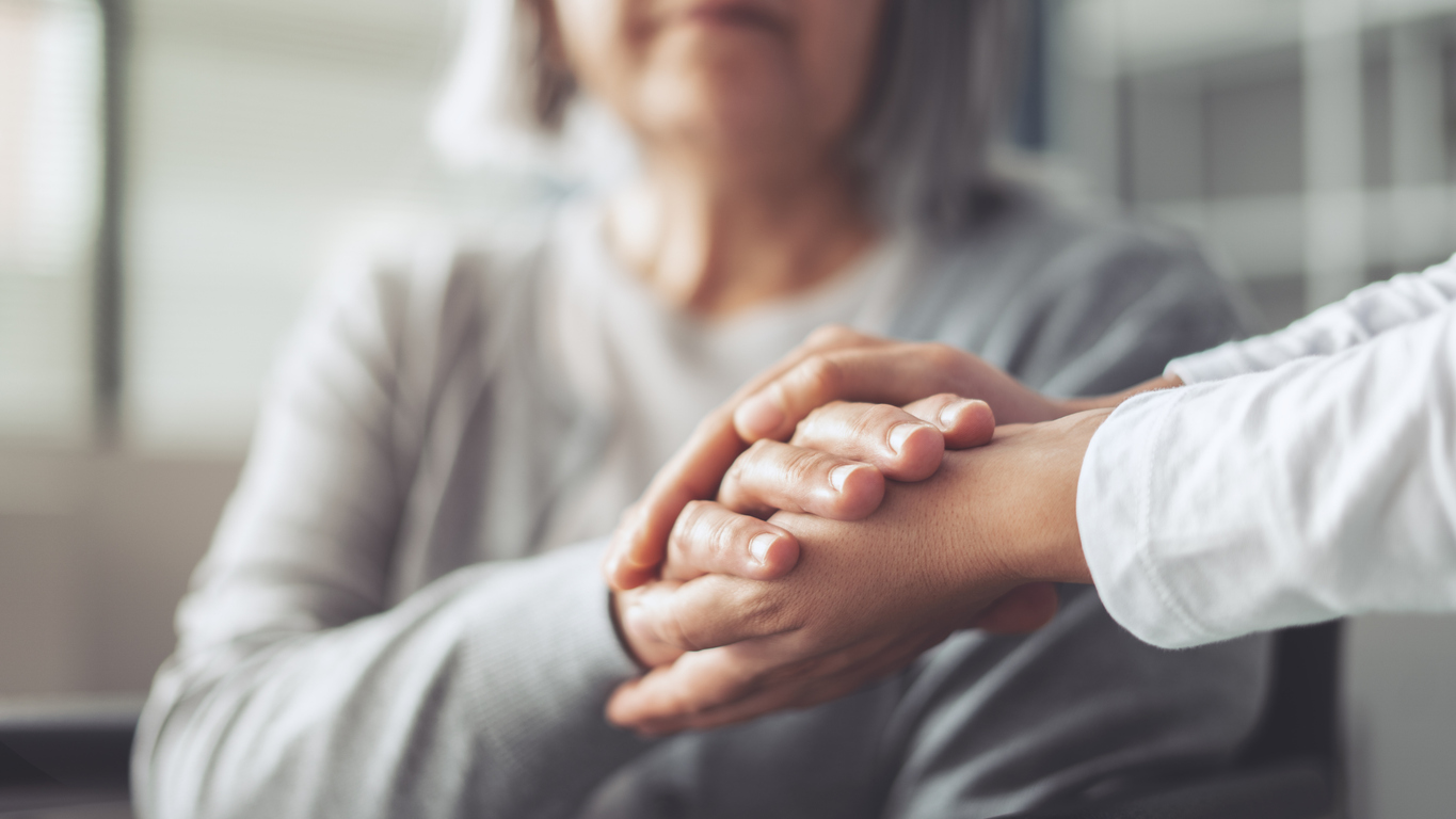 Holding hands with an elderly parent who needs help.