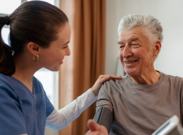 ComForCare Employee Helping Client Check Blood Pressure