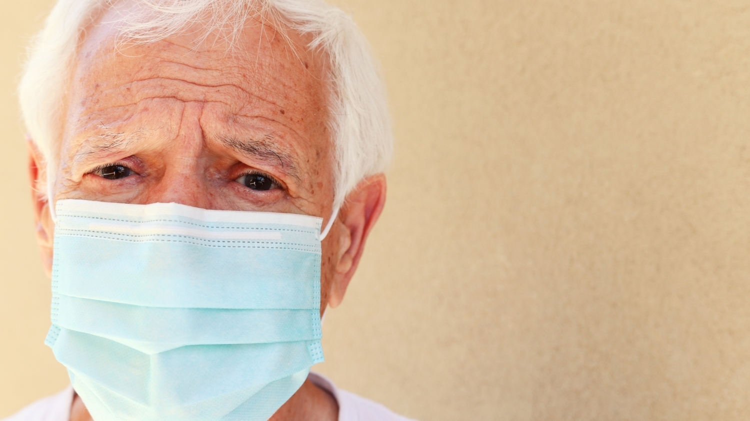 A photo of an older man wearing a face covering/mask.
