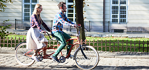A couple riding a tandem bike.
