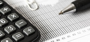 A photo of a calculator and some charts on a table.