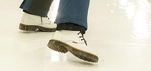 A pair of feet in tennis shoes that have tripped.