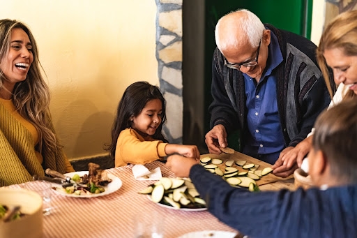 A family happily cooking together and laughing.