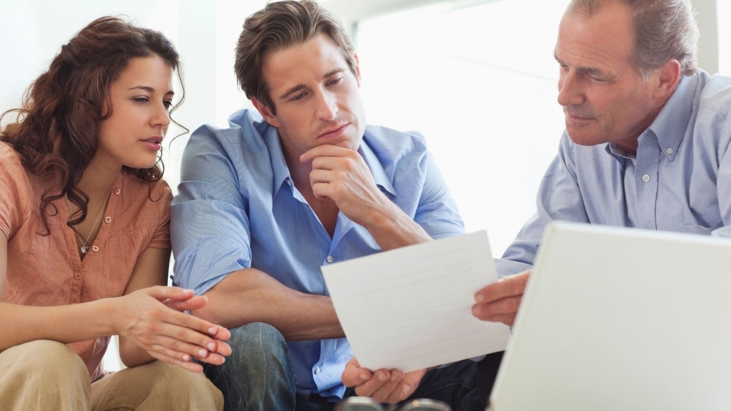 A group of 3 adults reviewing paperwork together.
