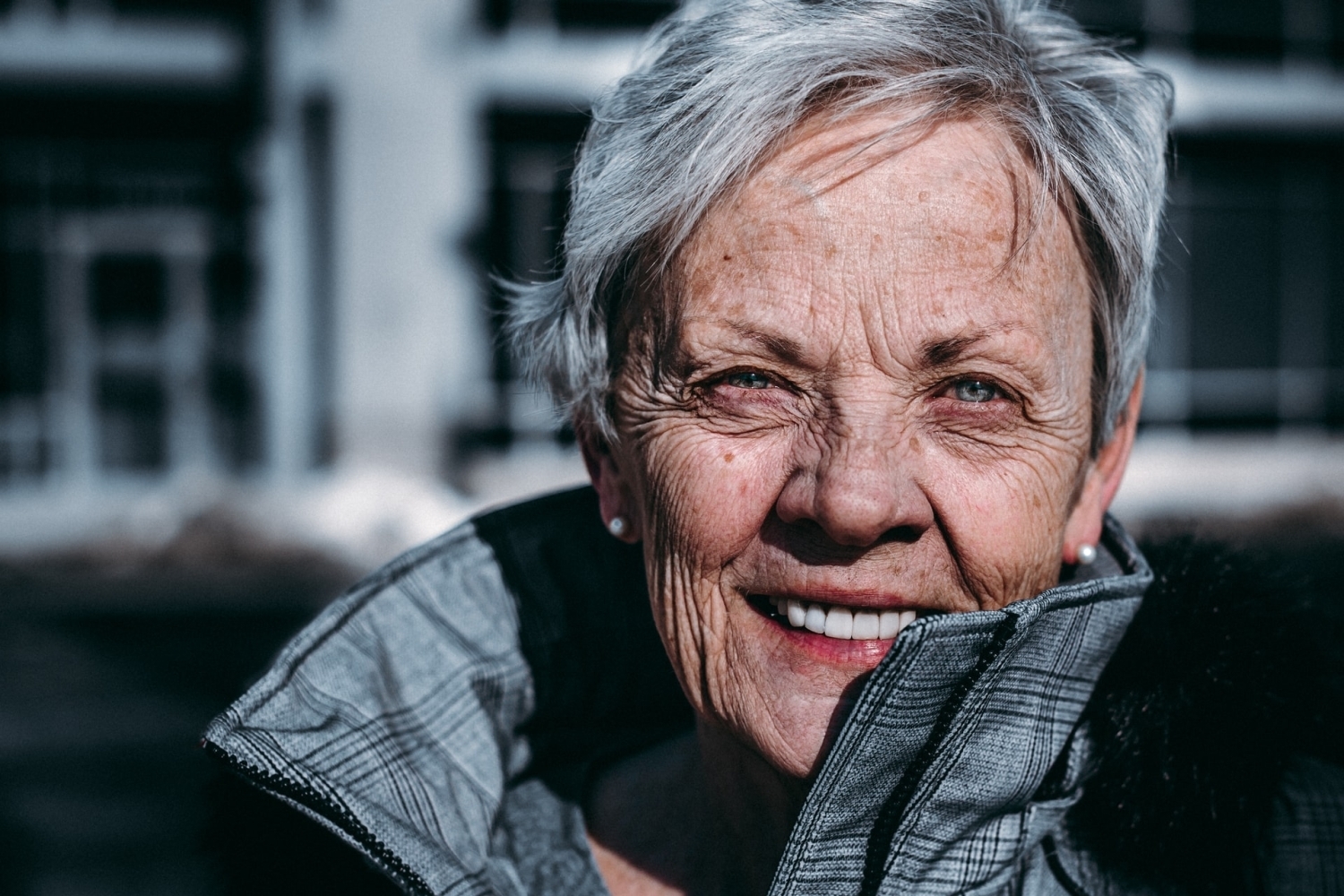 A close up photo of an older woman wearing a winter jacket.